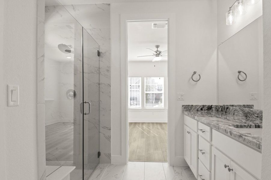Bathroom with a marble finish shower, vanity, light marble finish floors, and a ceiling fan Bathroom with a marble finish shower, vanity, light marble finish floors, and a ceiling fan