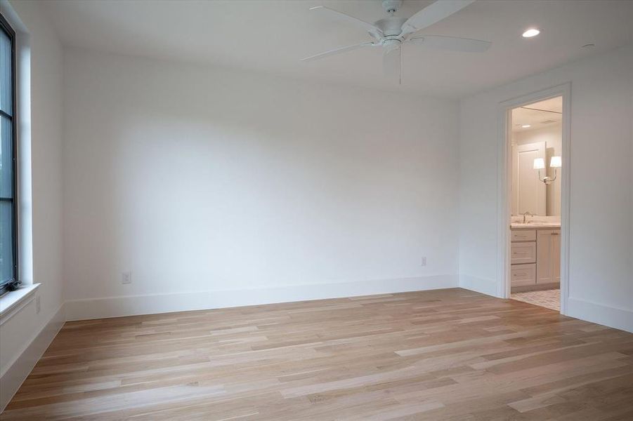 Unfurnished bedroom with ensuite bath, sink, ceiling fan, and light hardwood / wood-style floors