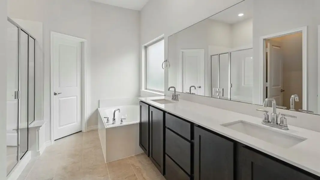Contemporary bathroom featuring a spacious dual vanity with dark wood-finish cabinetry and light-toned countertops
