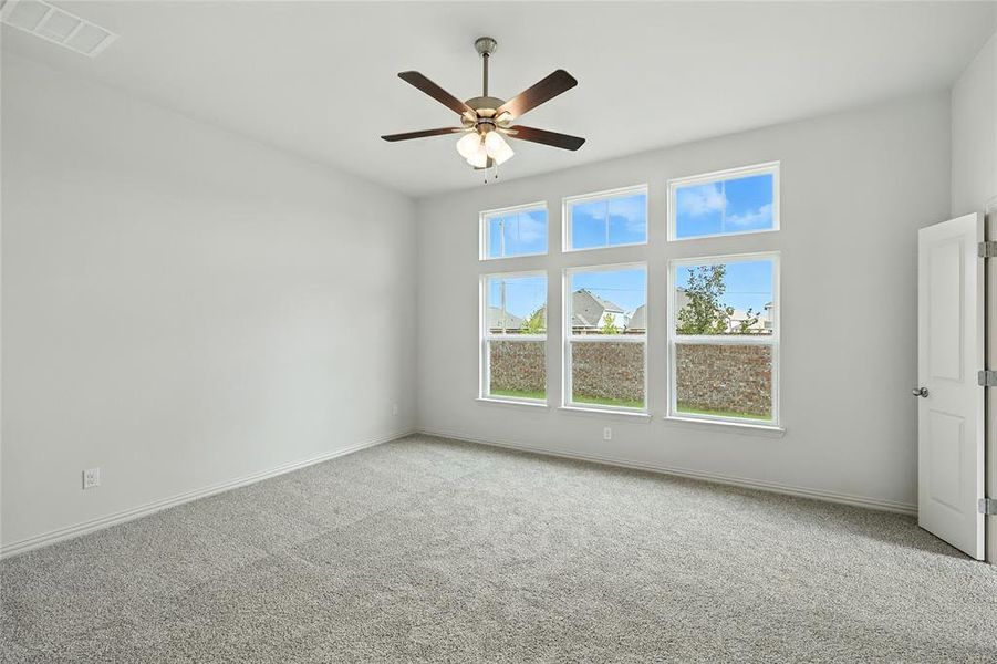 Empty room with carpet and a ceiling fan Empty room with carpet and a ceiling fan