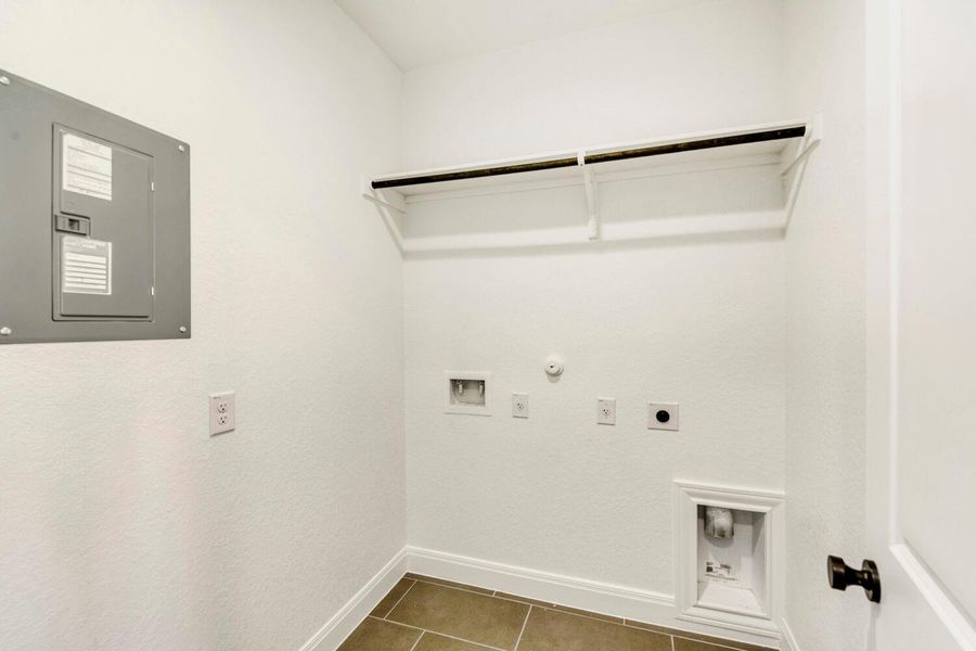 Laundry area with gas dryer hookup, electric panel, electric dryer hookup, dark tile patterned flooring, and hookup for a washing machine Laundry area with gas dryer hookup, electric panel, electric dryer hookup, dark tile patterned flooring, and hookup for a washing machine
