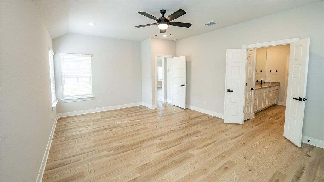 Unfurnished bedroom with light wood-style flooring, ceiling fan, connected bathroom, and recessed lighting Unfurnished bedroom with light wood-style flooring, ceiling fan, connected bathroom, and recessed lighting