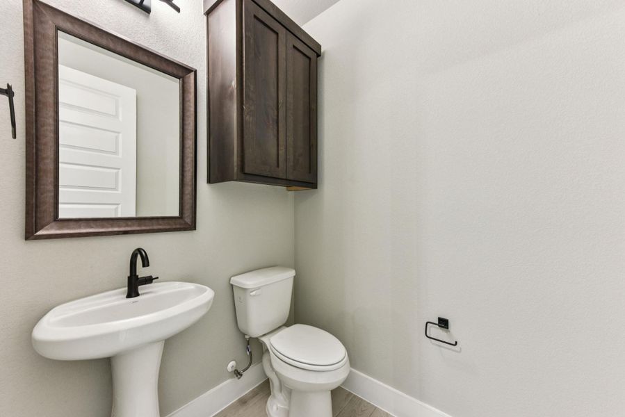 Half bath featuring baseboards and light wood-type flooring