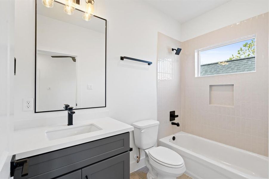 Secondary ensuite bath with quartz countertop and shower/tub combo.