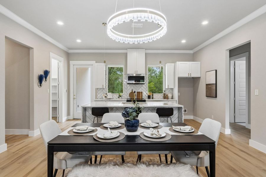 An open concept floorplan seamlessly blends kitchen and dining areas with bright hardwood flooring.