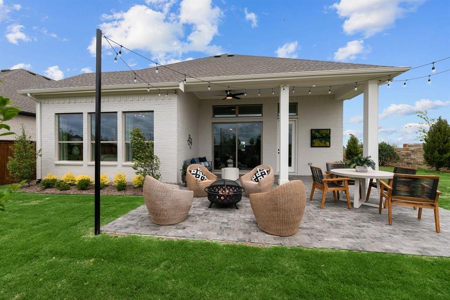 Back of house with a patio area, brick siding, a yard, an outdoor fire pit, and outdoor dining space Back of house with a patio area, brick siding, a yard, an outdoor fire pit, and outdoor dining space