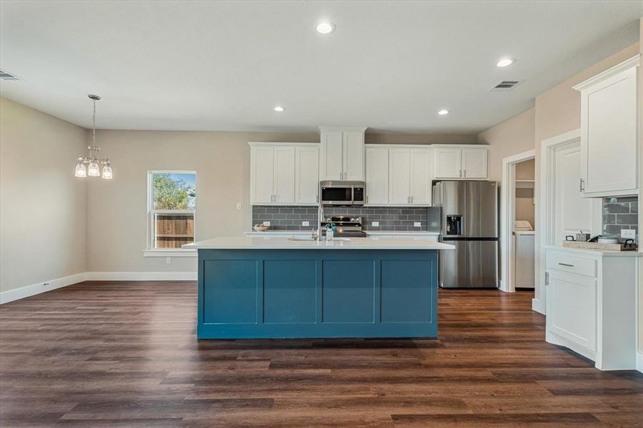Kitchen featuring white cabinetry, a center island with sink, dark hardwood / wood-style floors, and appliances with stainless steel finishes Kitchen featuring white cabinetry, a center island with sink, dark hardwood / wood-style floors, and appliances with stainless steel finishes