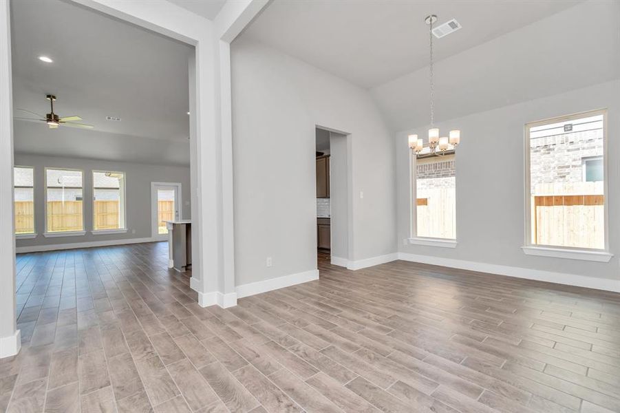 Create lasting memories with your family and friends at the dining table int this expansive dining room. It showcases sophisticated flooring, custom paint, and seamlessly connects to the family room and kitchen, providing an open and inviting atmosphere. Sample photo of completed home. Actual colors and selections may vary.