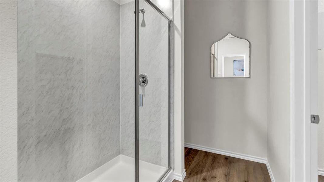 Full bath with a shower stall and light wood-type flooring Full bath with a shower stall and light wood-type flooring