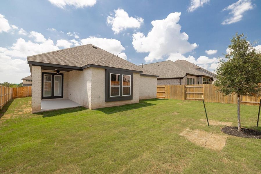 Back of house featuring brick siding, roof with shingles, a fenced backyard, a patio, and a ceiling fan Back of house featuring brick siding, roof with shingles, a fenced backyard, a patio, and a ceiling fan