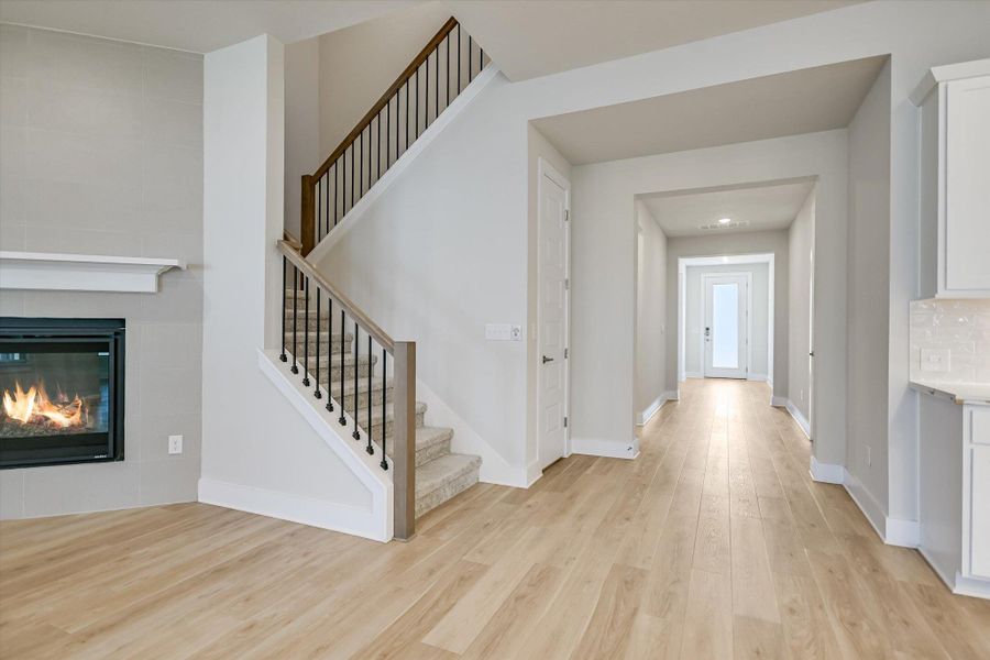 Smooth wood floors and a modern fireplace frame the soaring entry hall and staircase. Smooth wood floors and a modern fireplace frame the soaring entry hall and staircase.