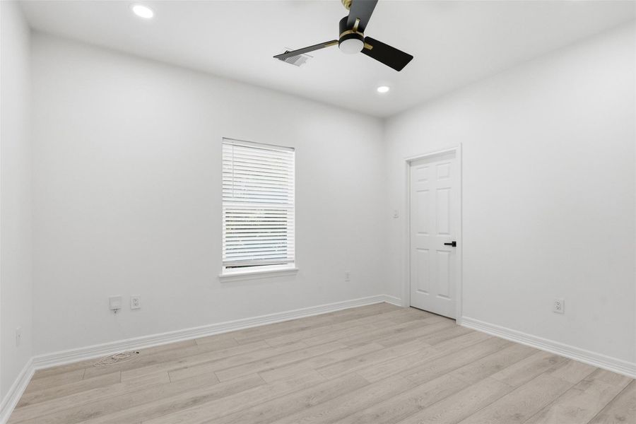 Bright second floor bedroom with ceiling fan, window, and neutral finishes throughout.