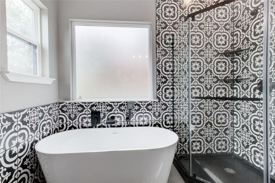 Full bath with a freestanding bath, a tile shower, and tile walls