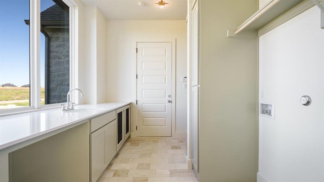 Laundry area with sink and hookup for a washing machine