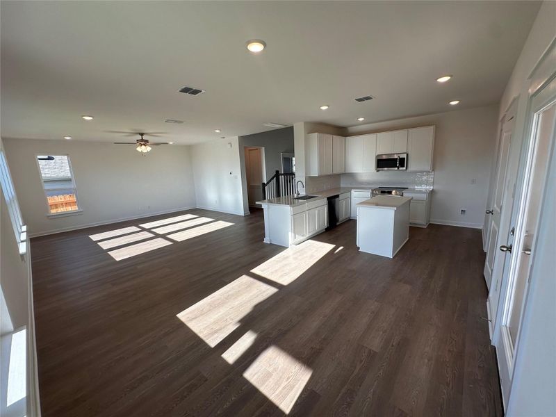 Kitchen featuring white cabinetry, open floor plan, a kitchen island, dark wood-style flooring, and recessed lighting Kitchen featuring white cabinetry, open floor plan, a kitchen island, dark wood-style flooring, and recessed lighting