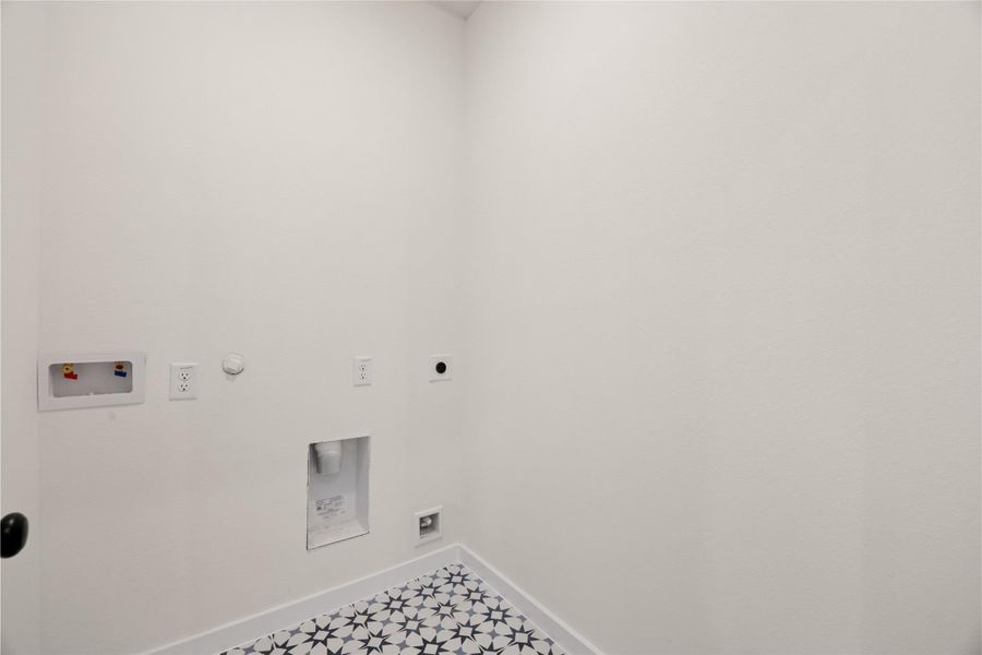 Laundry area right off of kitchen with custom tile. Laundry area right off of kitchen with custom tile.