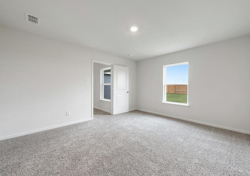 The master suite has a large window with backyard views.