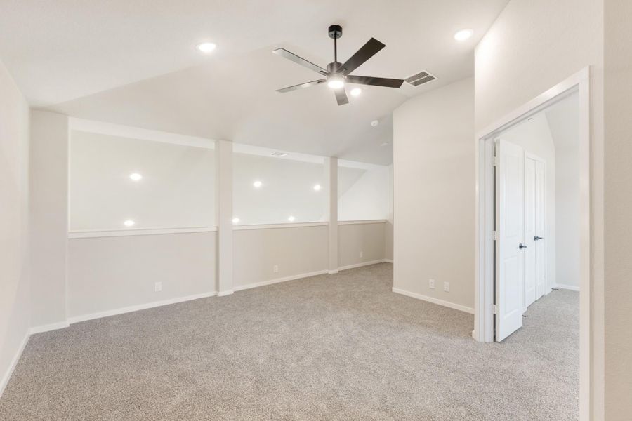 Empty bedroom with carpet flooring, ceiling fan, recessed lighting, and decorative wall panels