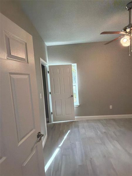Foyer entrance with wood finished floors, a ceiling fan, and a textured ceiling Foyer entrance with wood finished floors, a ceiling fan, and a textured ceiling
