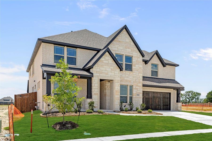 Two-story home with light stone exterior, dark trim, two-car garage, and manicured front lawn Two-story home with light stone exterior, dark trim, two-car garage, and manicured front lawn