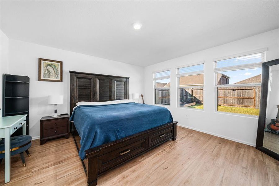 Primary bedroom with large windows.