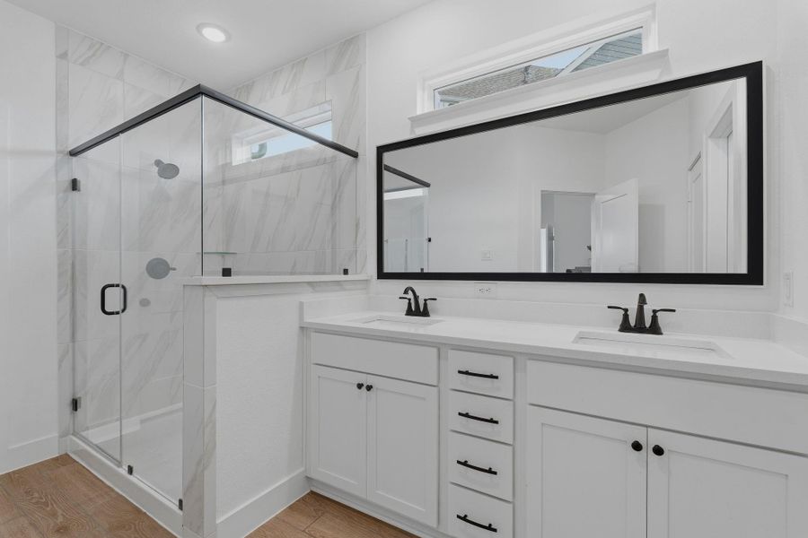 Primary bath with tall vanity, double sinks and stylish framed mirror. Large walk in closet too!