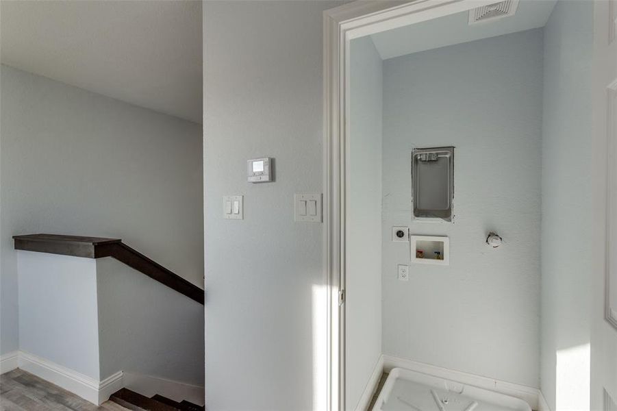 Laundry area with gas dryer hookup, hardwood / wood-style floors, washer hookup, and hookup for an electric dryer