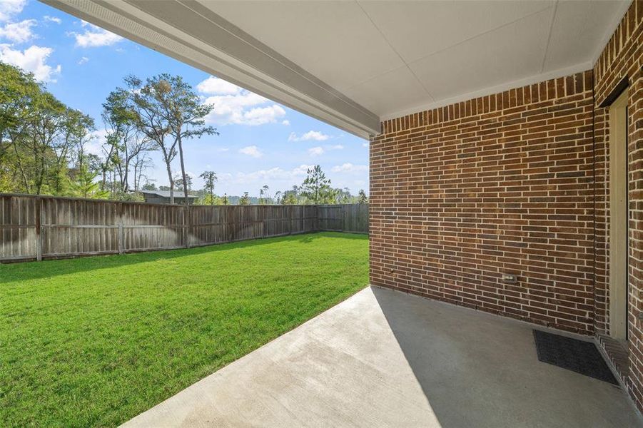 The covered patio in the back offers a perfect outdoor space for relaxing or entertaining, providing shade and comfort while enjoying the backyard.