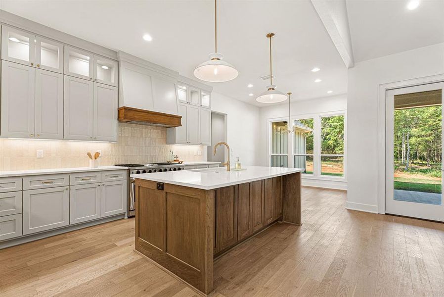 Kitchen with backsplash, pendant lighting, white cabinetry, glass insert cabinets, and recessed lighting