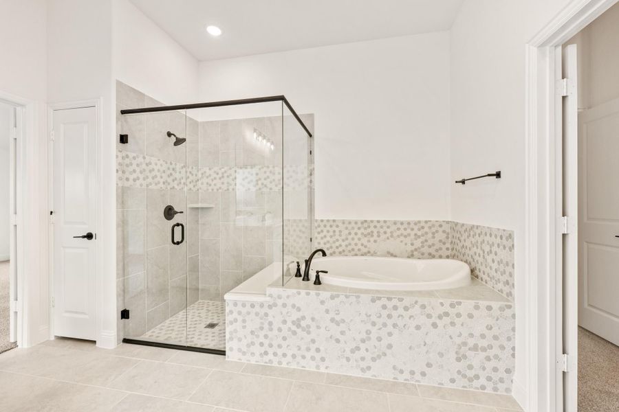 Master bathroom with glass-enclosed shower, soaking tub, mosaic tile surround, and black fixtures