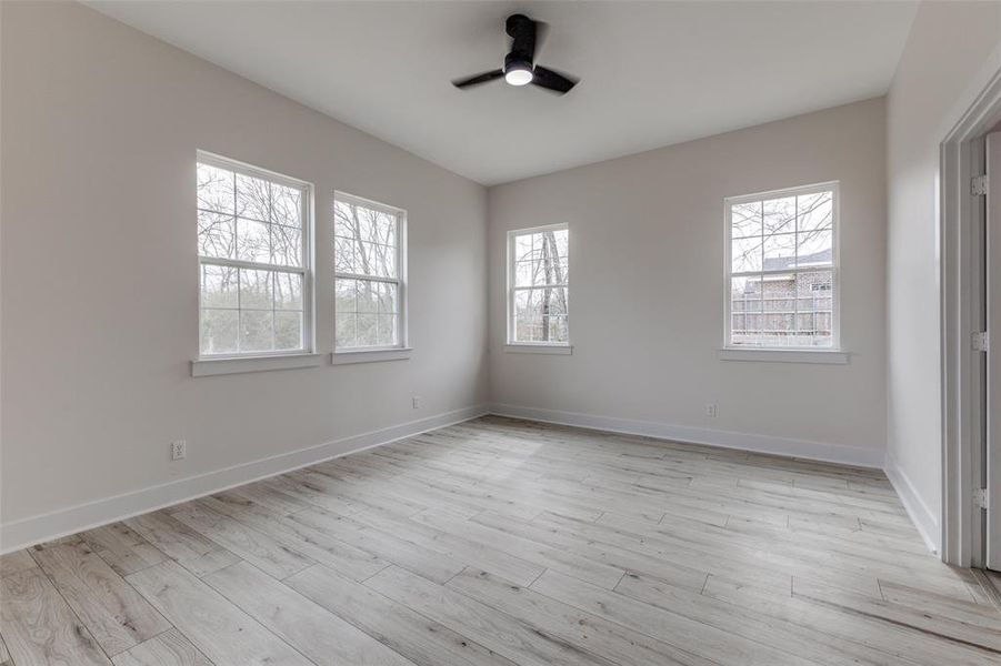 Unfurnished bedroom with baseboards, light wood-style floors, and ceiling fan