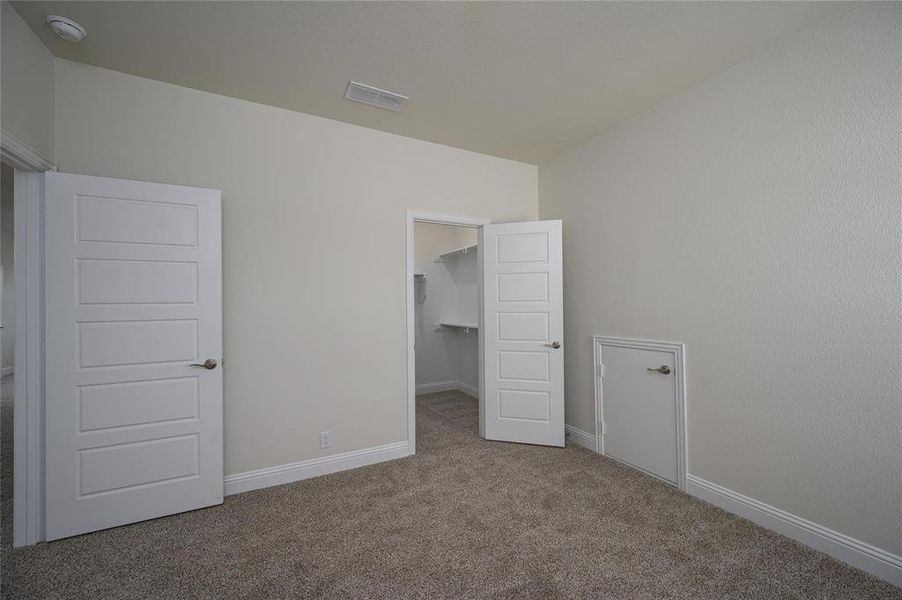 Unfurnished bedroom with a closet, carpet floors, and a walk in closet