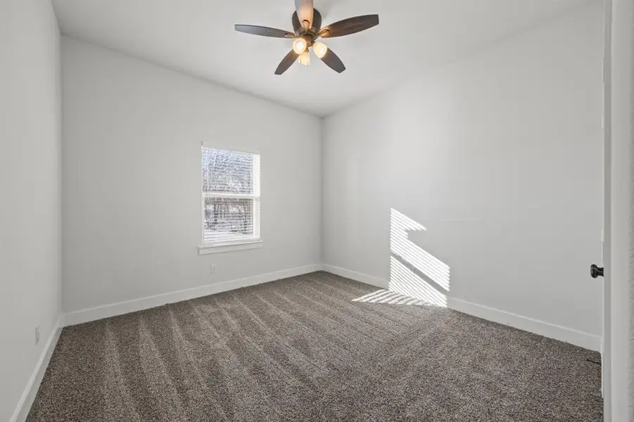 Spare room featuring carpet floors and ceiling fan