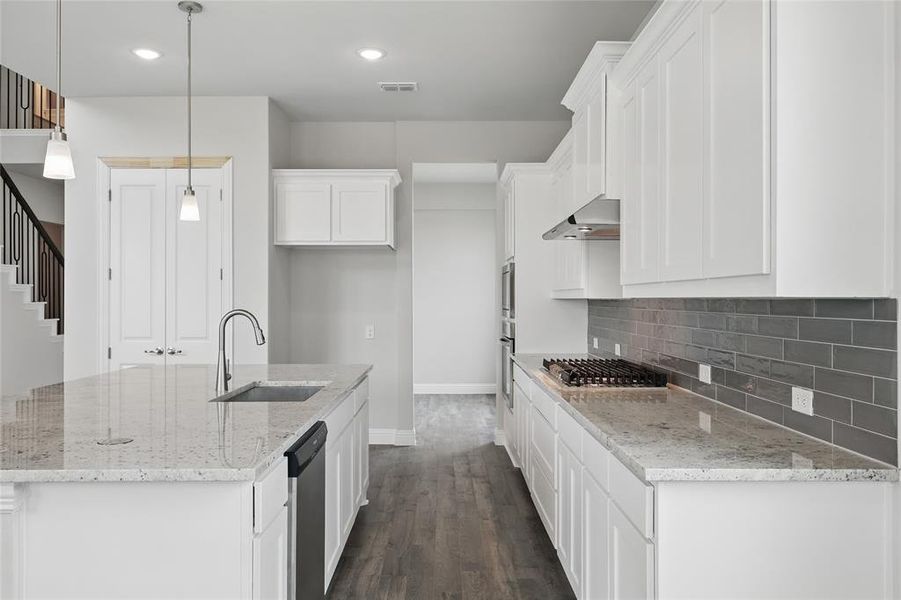 Kitchen with a sink, appliances with stainless steel finishes, baseboards, white cabinetry, and tasteful backsplash Kitchen with a sink, appliances with stainless steel finishes, baseboards, white cabinetry, and tasteful backsplash