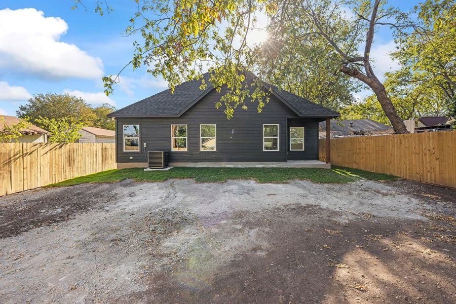 Back of house with a patio area, a fenced backyard, and a shingled roof Back of house with a patio area, a fenced backyard, and a shingled roof
