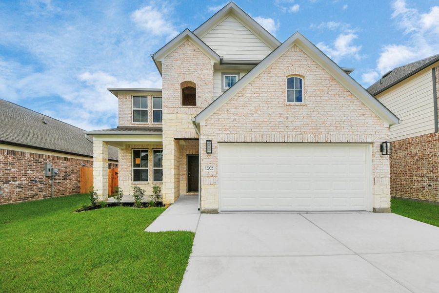 This home boasts lush green grass and meticulous landscaping. Its premium elevation showcases an exquisite blend of brick and stone features, complemented by modern coach lighting This home boasts lush green grass and meticulous landscaping. Its premium elevation showcases an exquisite blend of brick and stone features, complemented by modern coach lighting