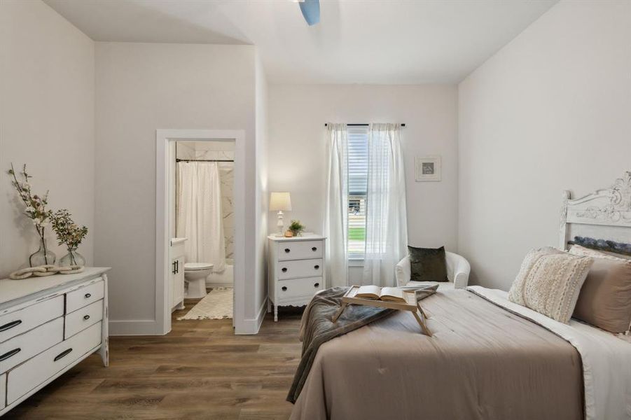 Bedroom featuring wood-finish flooring, a white headboard with carved details, and a window with blinds and sheer curtains