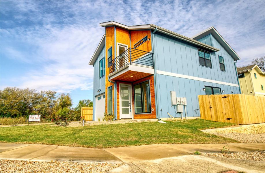 View of front of home with a balcony, a garage, and board and batten siding
