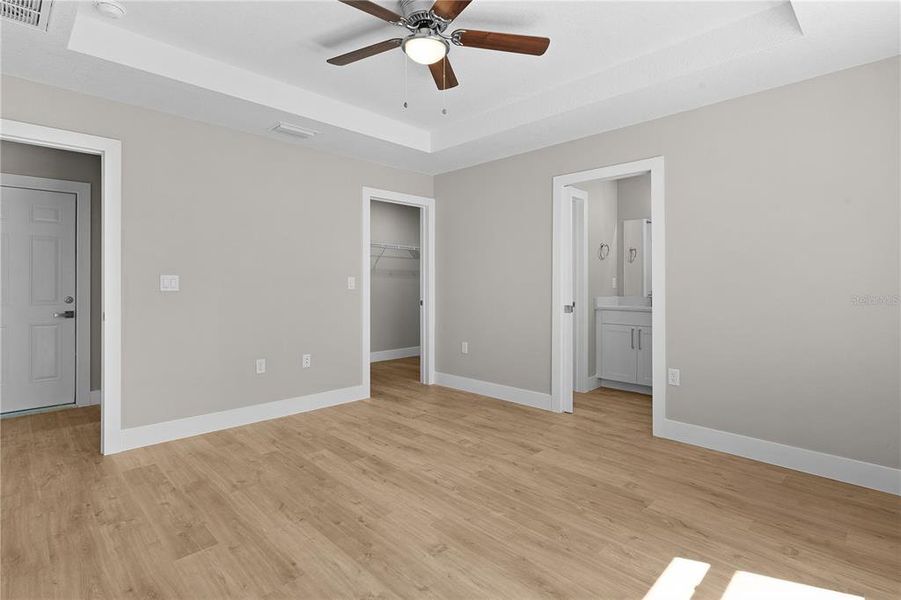 Primary bedroom with bathroom door on the right and walk-in-closet door in the middle