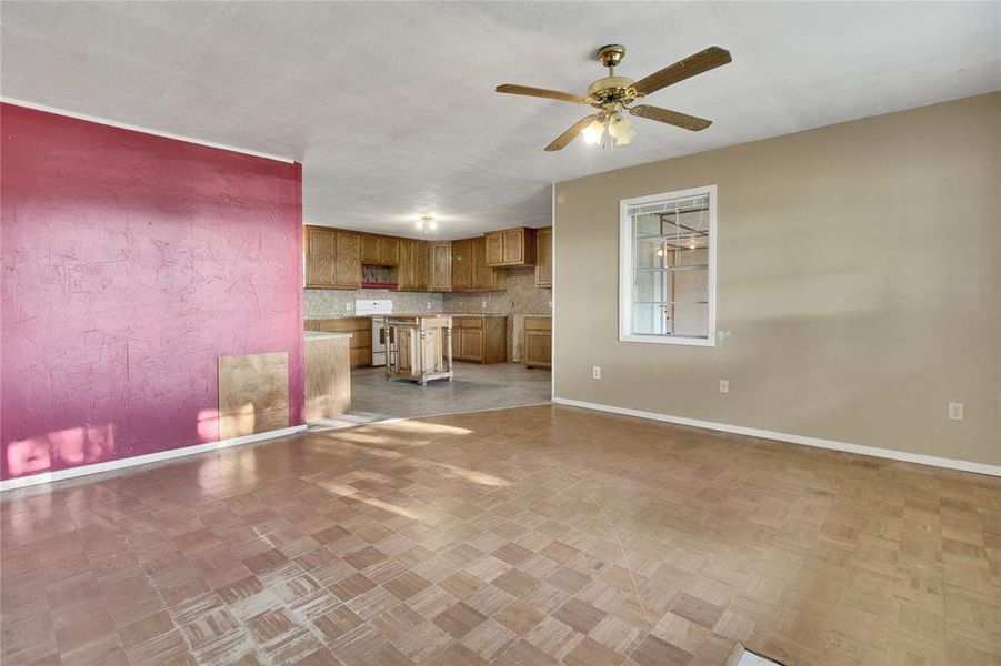 Unfurnished living room with baseboards and a ceiling fan Unfurnished living room with baseboards and a ceiling fan