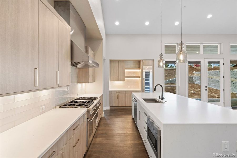 Chef's kitchen with quartz countertop with stunning waterfall edge, separate wine fridge, counter seating for 6+, and custom organization including a spice cabinet and roll-outs.