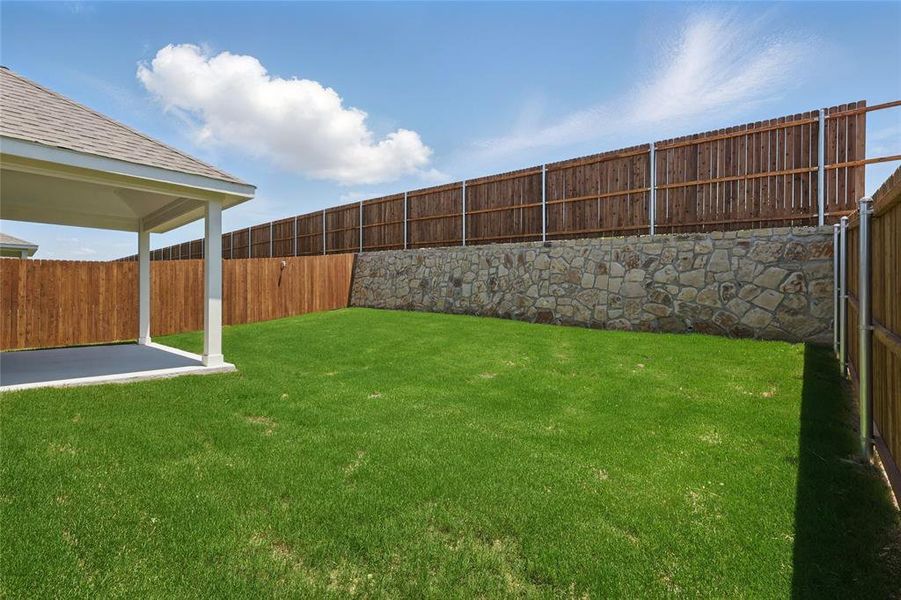 Fenced backyard with a patio area Fenced backyard with a patio area