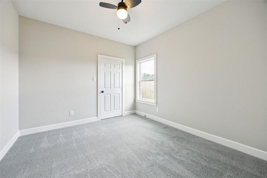 Spare room with carpet flooring and a ceiling fan Spare room with carpet flooring and a ceiling fan