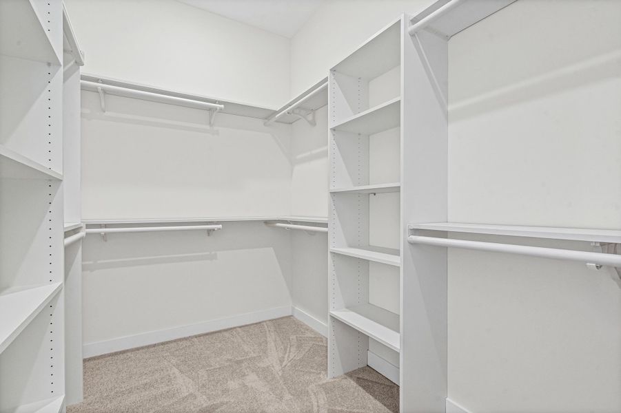 Walk-in closet with integrated shelving units and hanging rods Walk-in closet with integrated shelving units and hanging rods