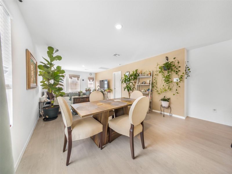 Dining room with light wood-style floors and recessed lighting