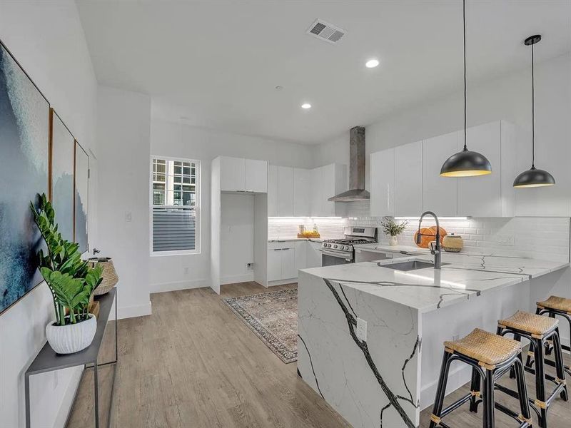 Kitchen featuring a kitchen bar, white cabinetry, a peninsula, decorative backsplash, and modern cabinets