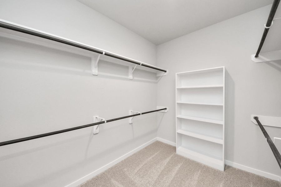 Walk-in closet that epitomizes luxury and practicality. This generously sized space features built-in shelving, offering abundant room for impeccable organization. High ceilings and recessed lighting create a bright and welcoming ambiance.