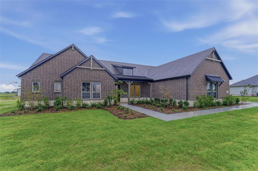 Brick exterior with dark gray shingles, featuring a covered entry porch, multiple gables, and a window awning Brick exterior with dark gray shingles, featuring a covered entry porch, multiple gables, and a window awning