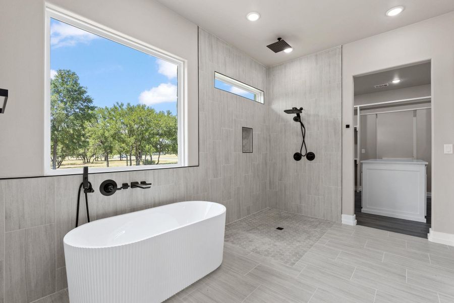 A well-appointed bath features a deep soaking tub and an open shower with views of the natural surroundings. A well-appointed bath features a deep soaking tub and an open shower with views of the natural surroundings.