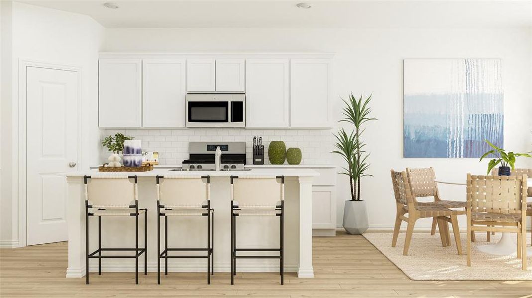 Kitchen featuring tasteful backsplash, white cabinets, a breakfast bar area, light hardwood / wood-style floors, and appliances with stainless steel finishes